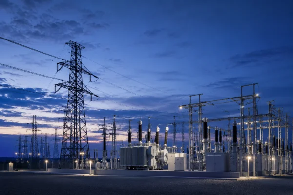 High-voltage transmission lines and substation at dusk